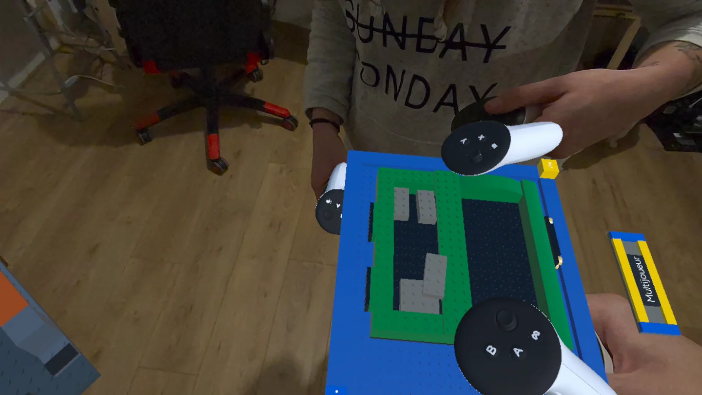 Two players' Touch controllers around a shared brick building board in mixed reality.